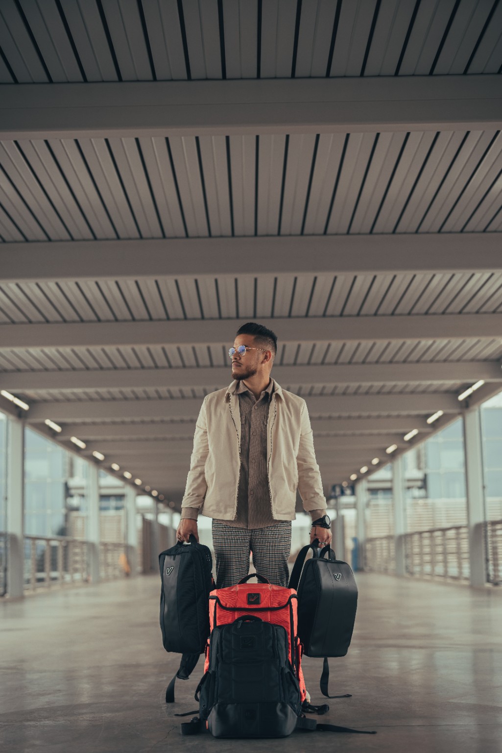 Kevin Michael Chong carrying Gruv Gear bags in a covered walkway