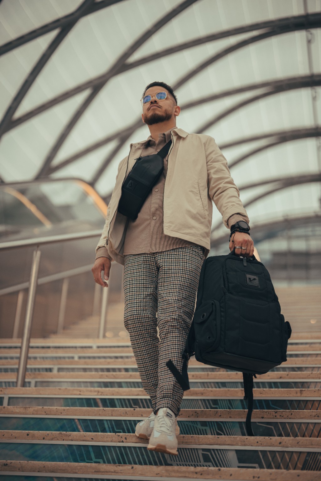 Kevin Michael Chong walking downstairs with a Gruv Gear backpack